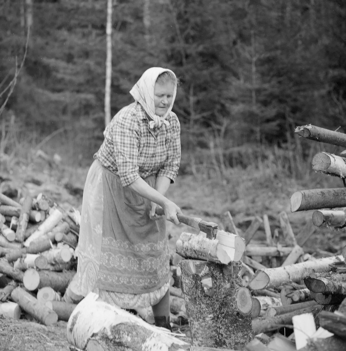 Vanha nainen hakkaa halkoja kuvaaja Teuvo Kanerva Museovirasto Historian kuvakokoelma
