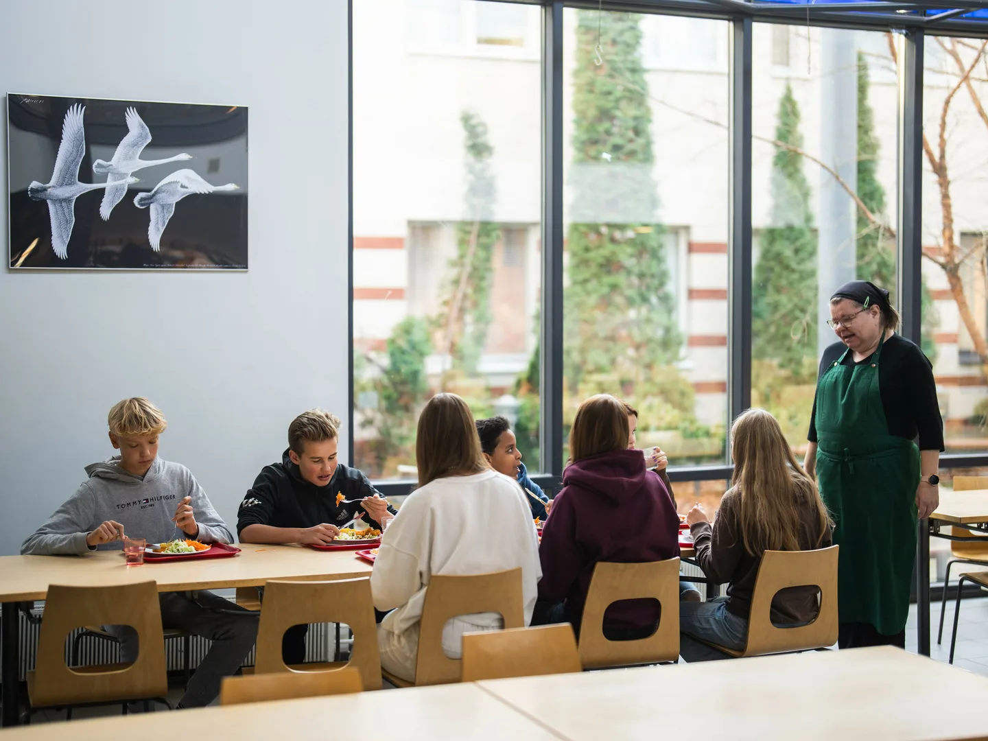 Lapsia syömässä kouluruokaa pöydän ääressä_ruokapalveluhenkilö pöydän viereressä_kuva_Ruokakasvastusyhdistys Ruukku ry