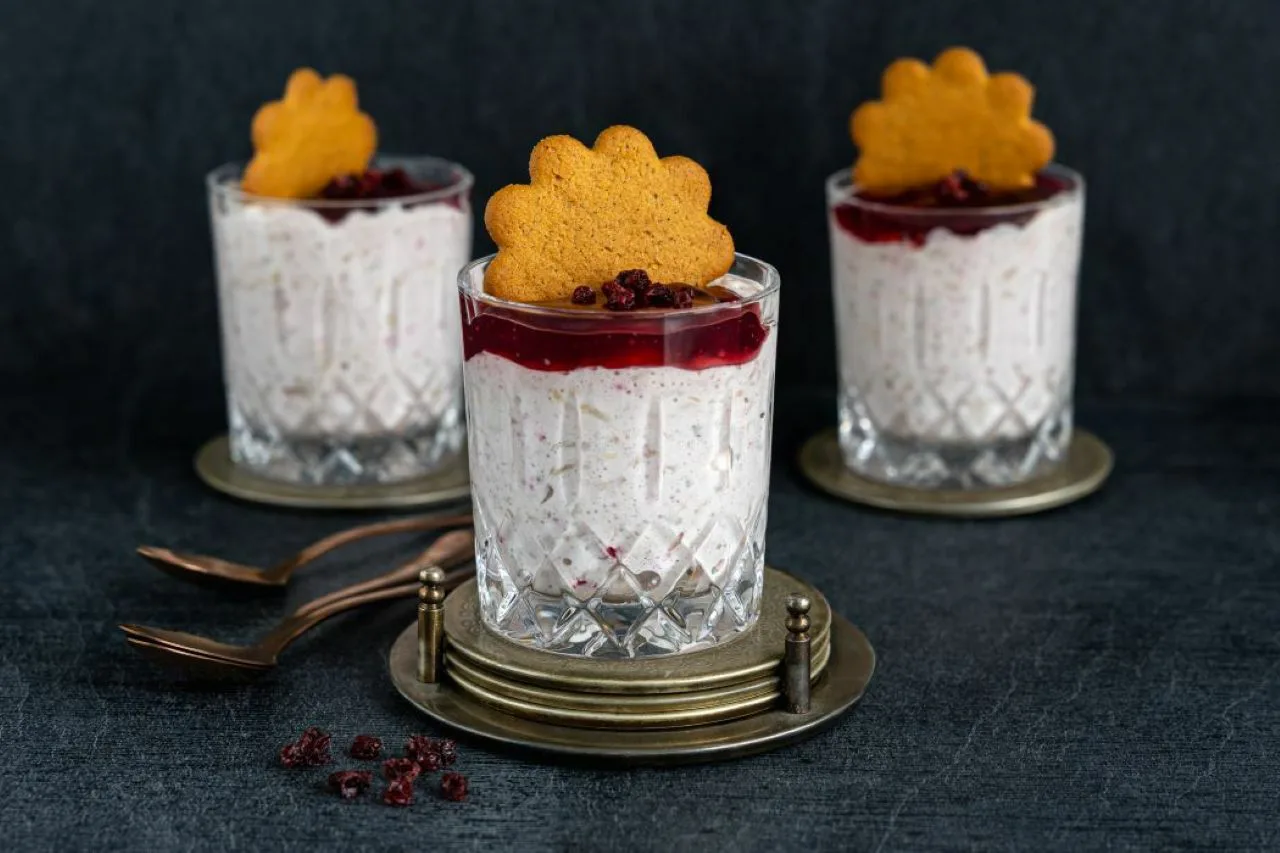 kolmessa lasinalusilla olevissa laseissa puuroa, päällä punaista keittoa ja pipari