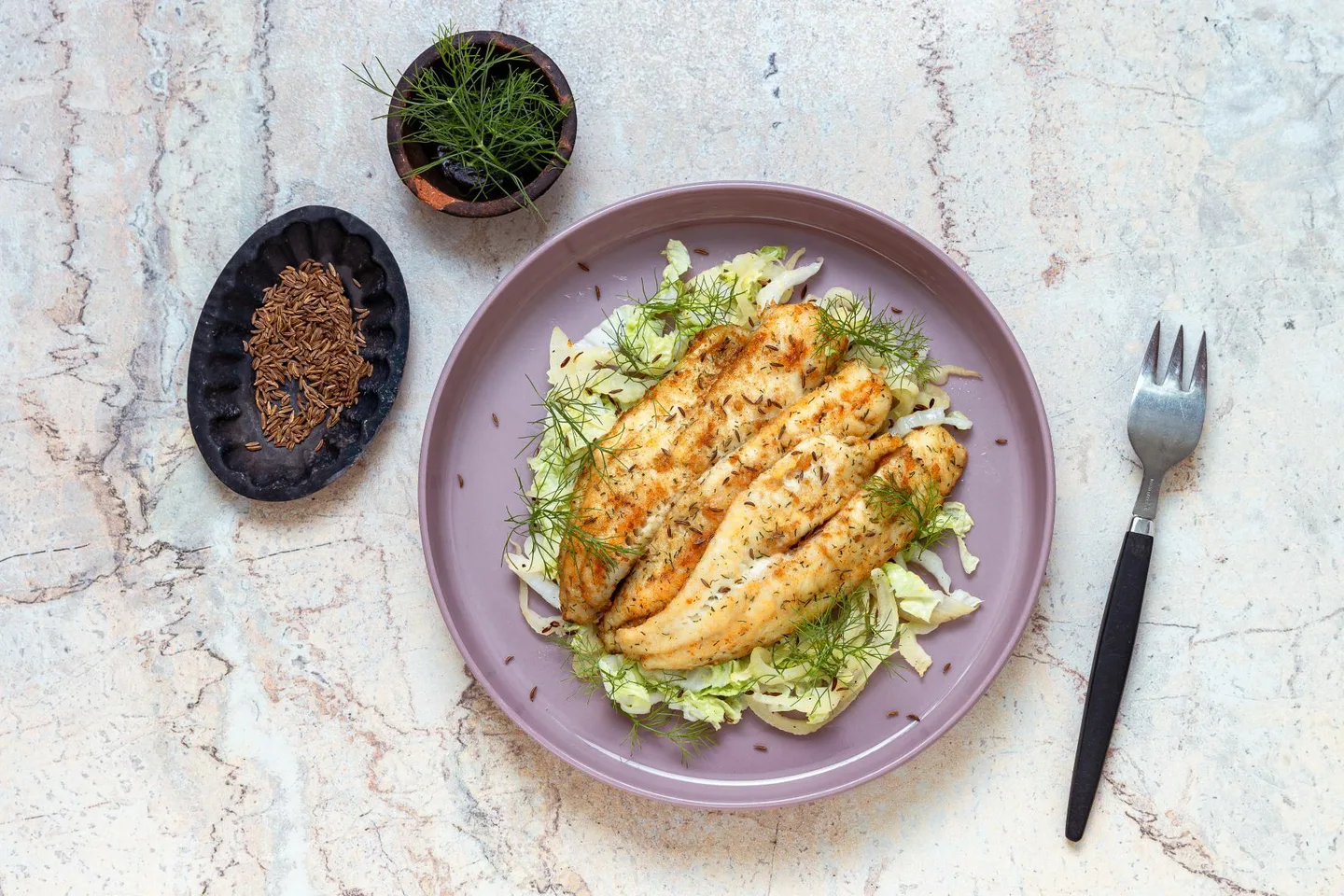 paistettuja ahvenia kiinankaalihöystön päällä, kuminaa