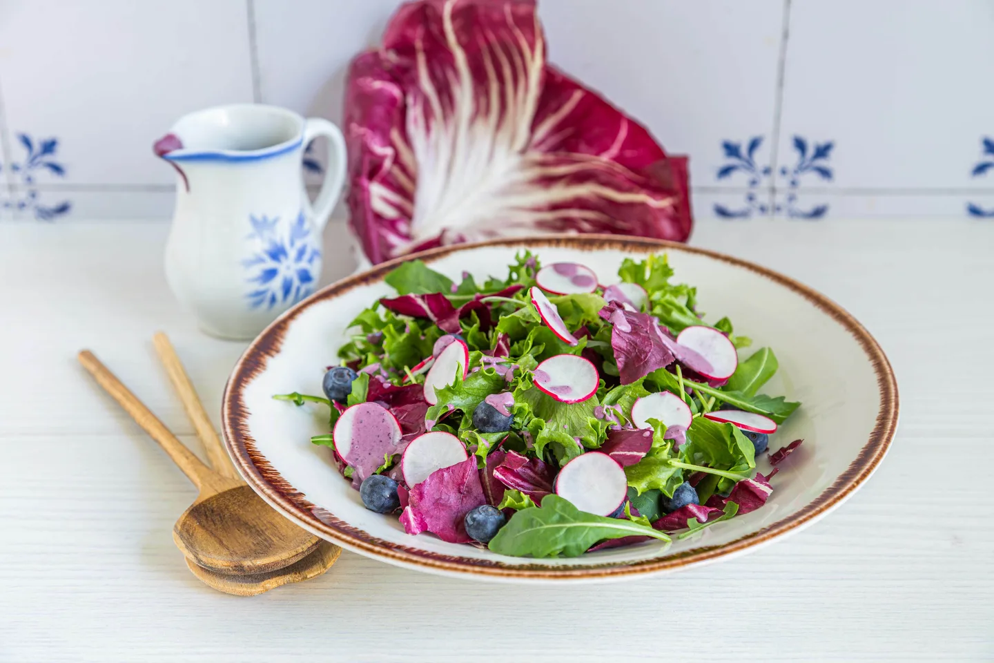 Punasikuria, retiisiä, salaattia, mustikoita lautasella