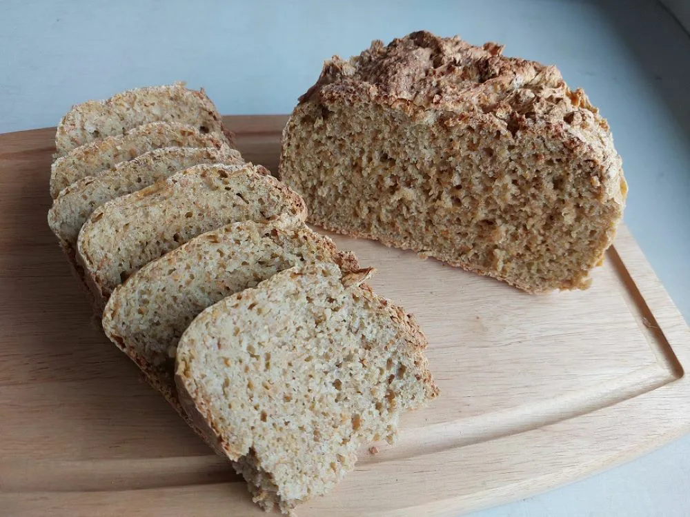 leivänpuolikas ja leipäviipaleita puisella leikkuulaudalla