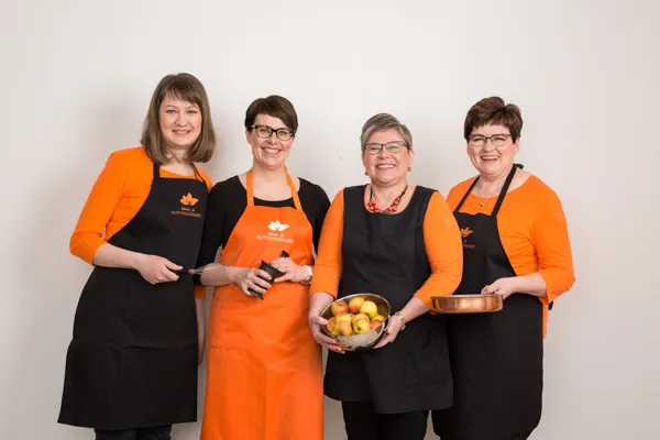 Neljä nauravaa naista MKN-essuissaan