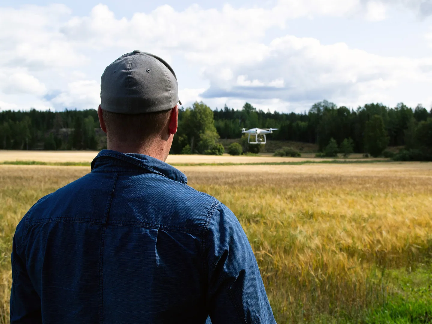 Kuvituskuva mies ja drone pellon laidalla kuva Kaisa Uusi Kraapo