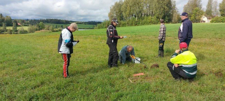 Ihmisiä tutkimassa peltoa