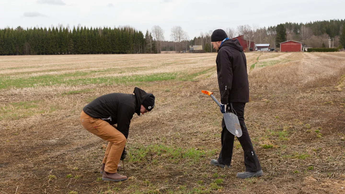 Ihmisia pellolla huhtikuussa maanrakenteen tutkimista