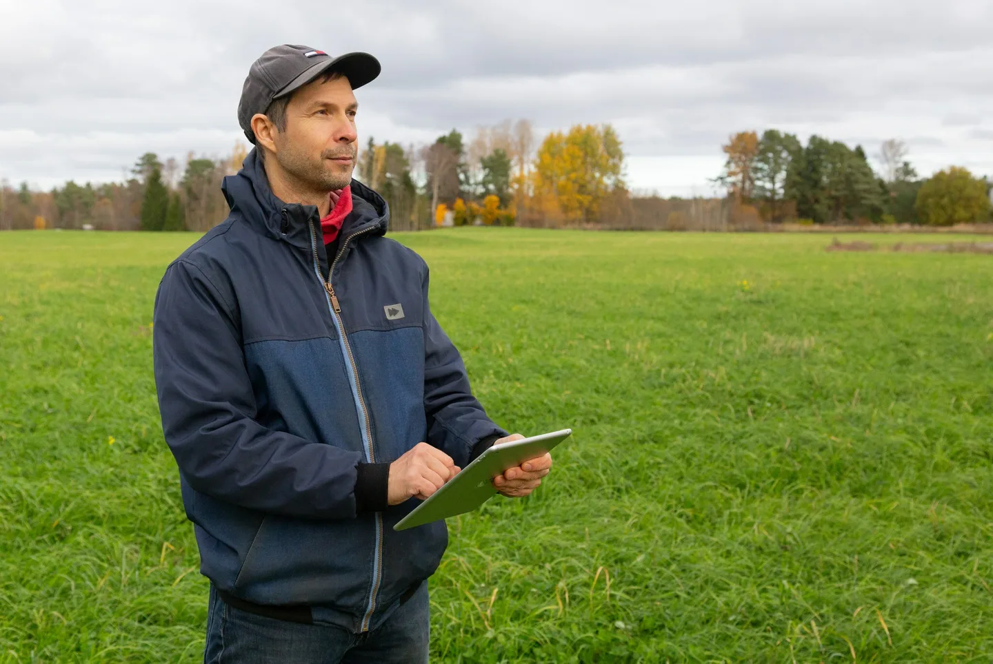 Ihminen pellolla tabletti kädessä