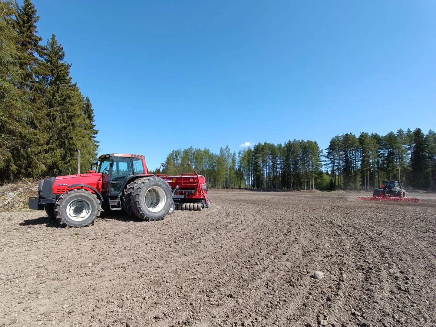 Traktori ja kylvökone pellolla