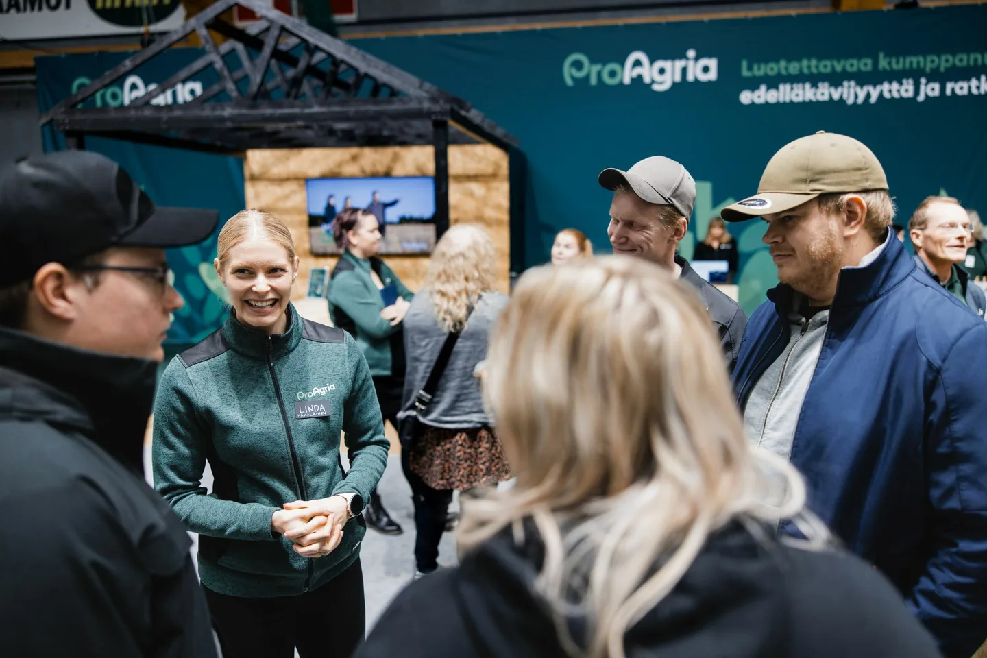 ProAgrian asiantuntija Linda Hamalainen asiakkaiden kanssa KoneAgria messusosastolla
