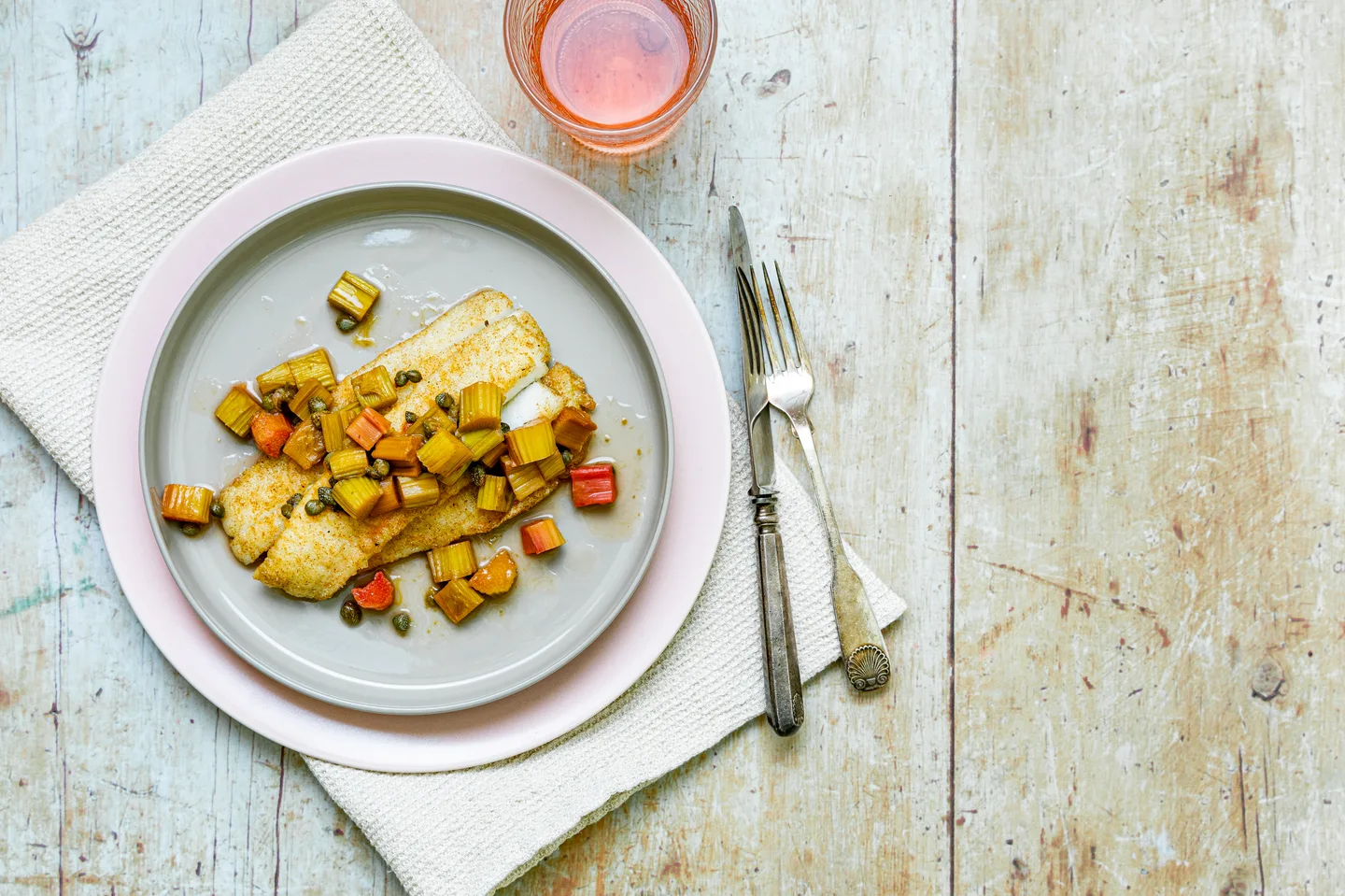 Lautasella paistettua kalaa ja raparperia