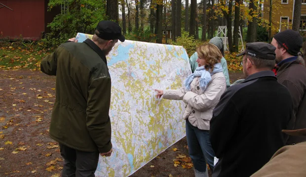 Tutkimassa tilan sijaintia kartalta käsin.